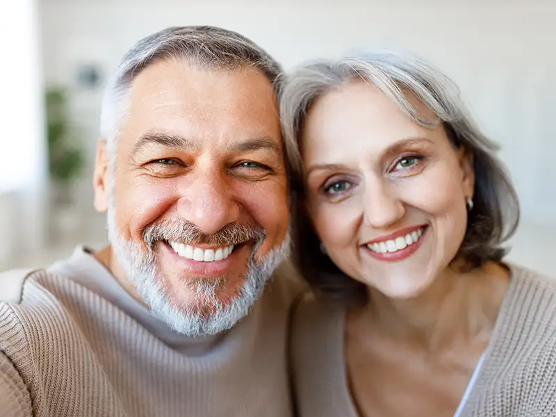 mature man and woman smiling together indoors at home