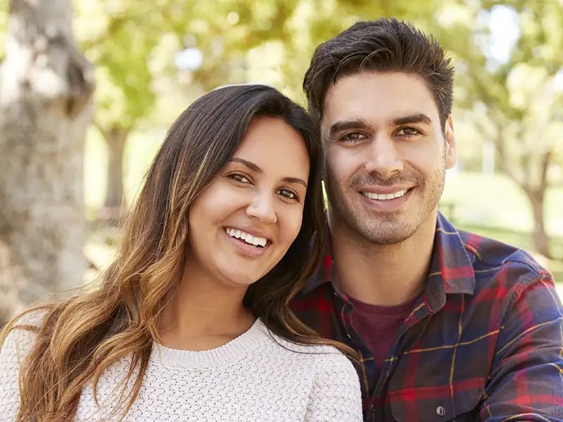 young man and woman smiling in the park