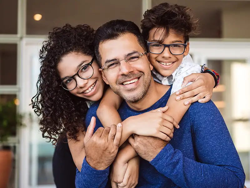 father smiling with son and daughter