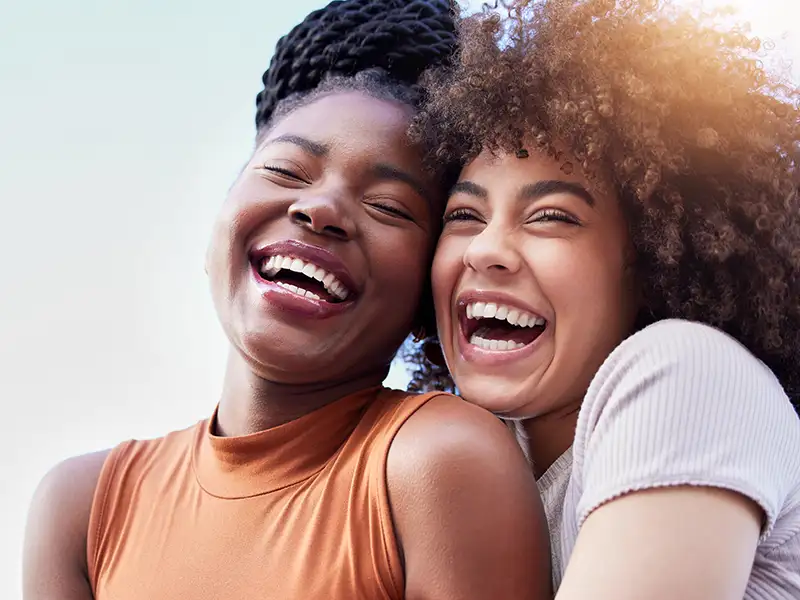 two women laughing and smiling together