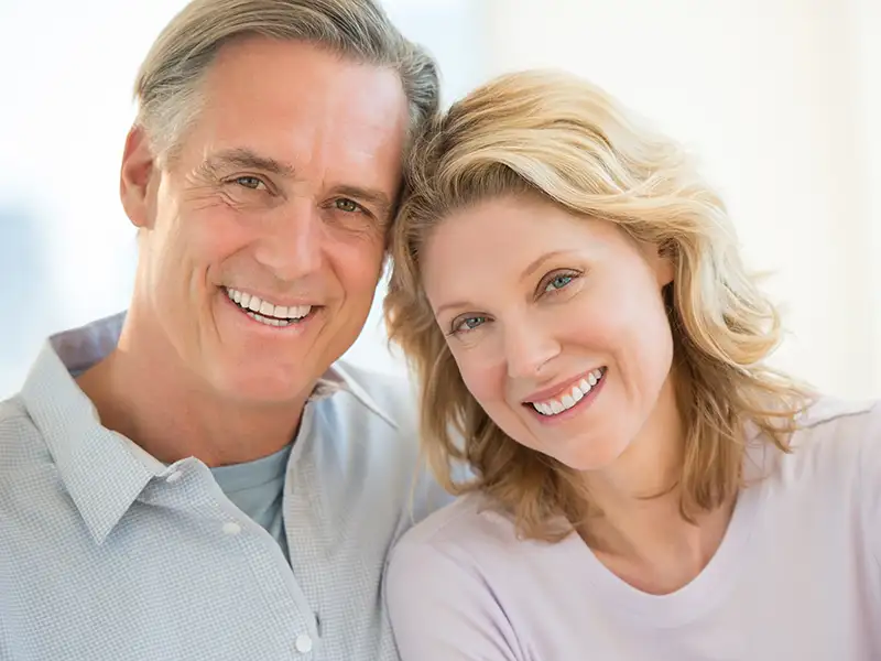 mature man and woman smiling together indoors