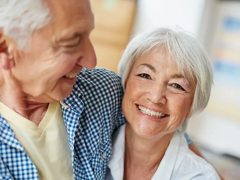 senior man and woman smiling together at home