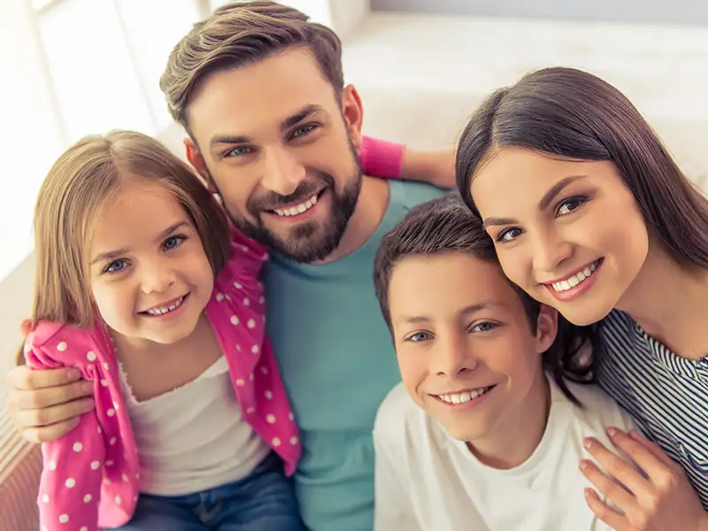 mother and father smiling with son and daughter at home