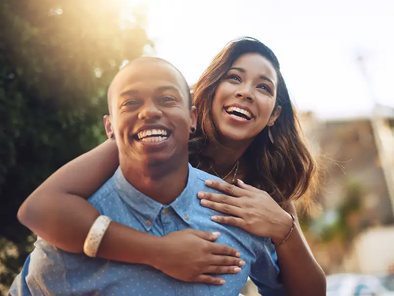 man and woman smiling together outdoors in the city