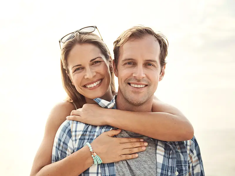 man and woman smiling together outdoors