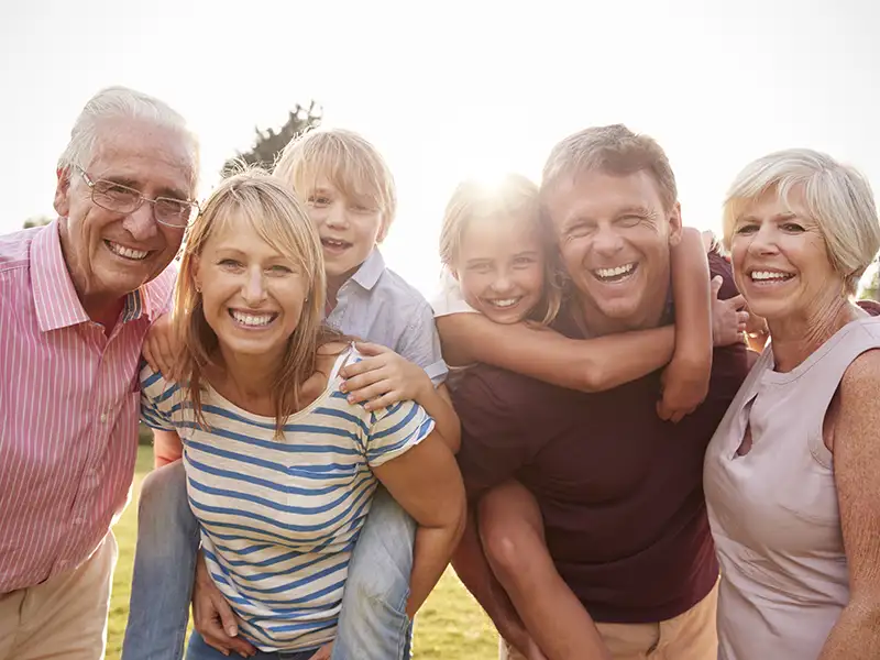 multi generational family smiling together outdoors