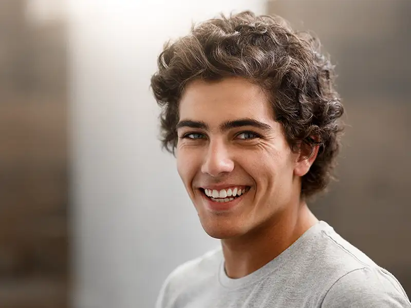 young man smiling indoors at home