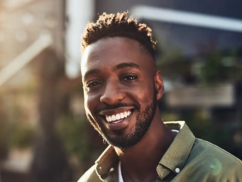 young man smiling outdoors in city
