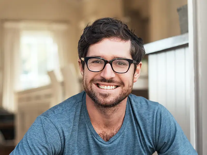 man smiling indoors at home