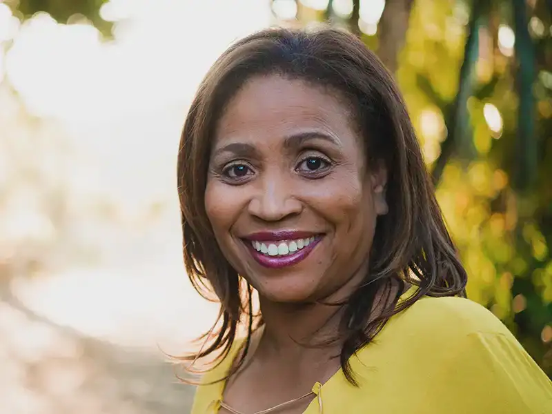 adult woman smiling outdoors near trees