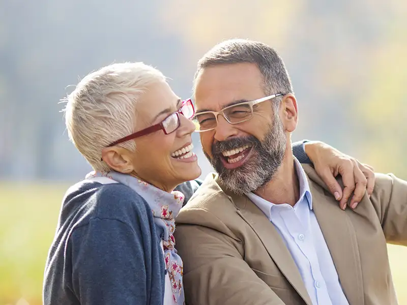 senior man and woman smiling together in the park