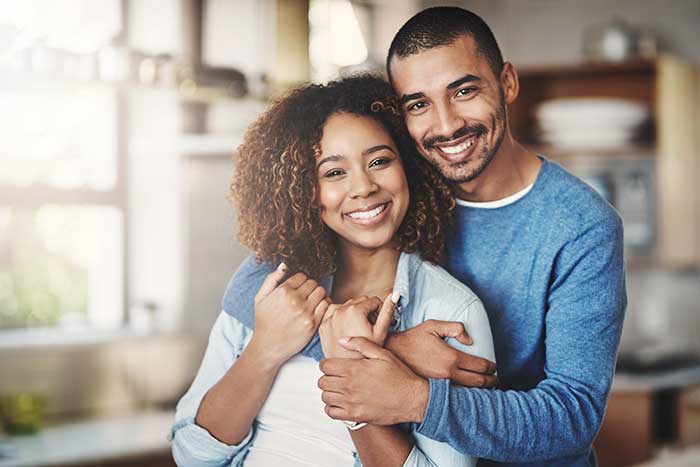 young man and woman smiling together at home